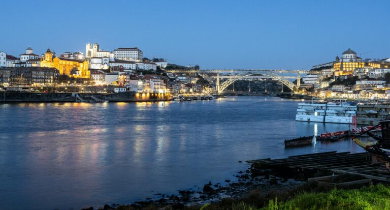 Night view of Porto, Portugal with the illuminated Dom Luís I Bridge spanning the Douro River.