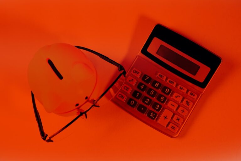 Um Cofrinho E Uma Calculadora Sobre Um Fundo Laranja kGHieYrMa38