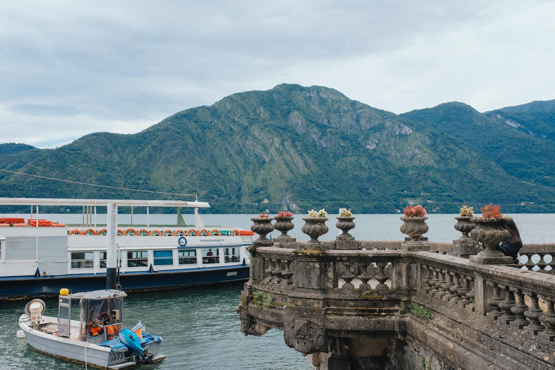 Beautiful lake view with boats and mountains in a serene setting.