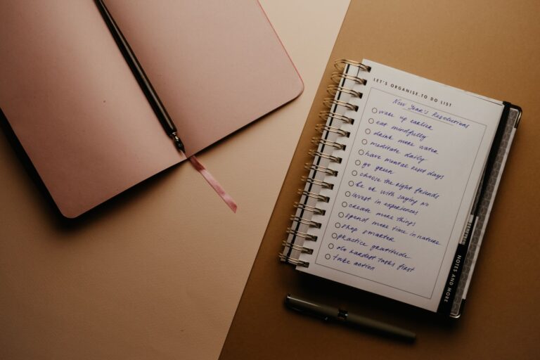 Top view of open planner with handwritten New Year's resolutions on a desk.