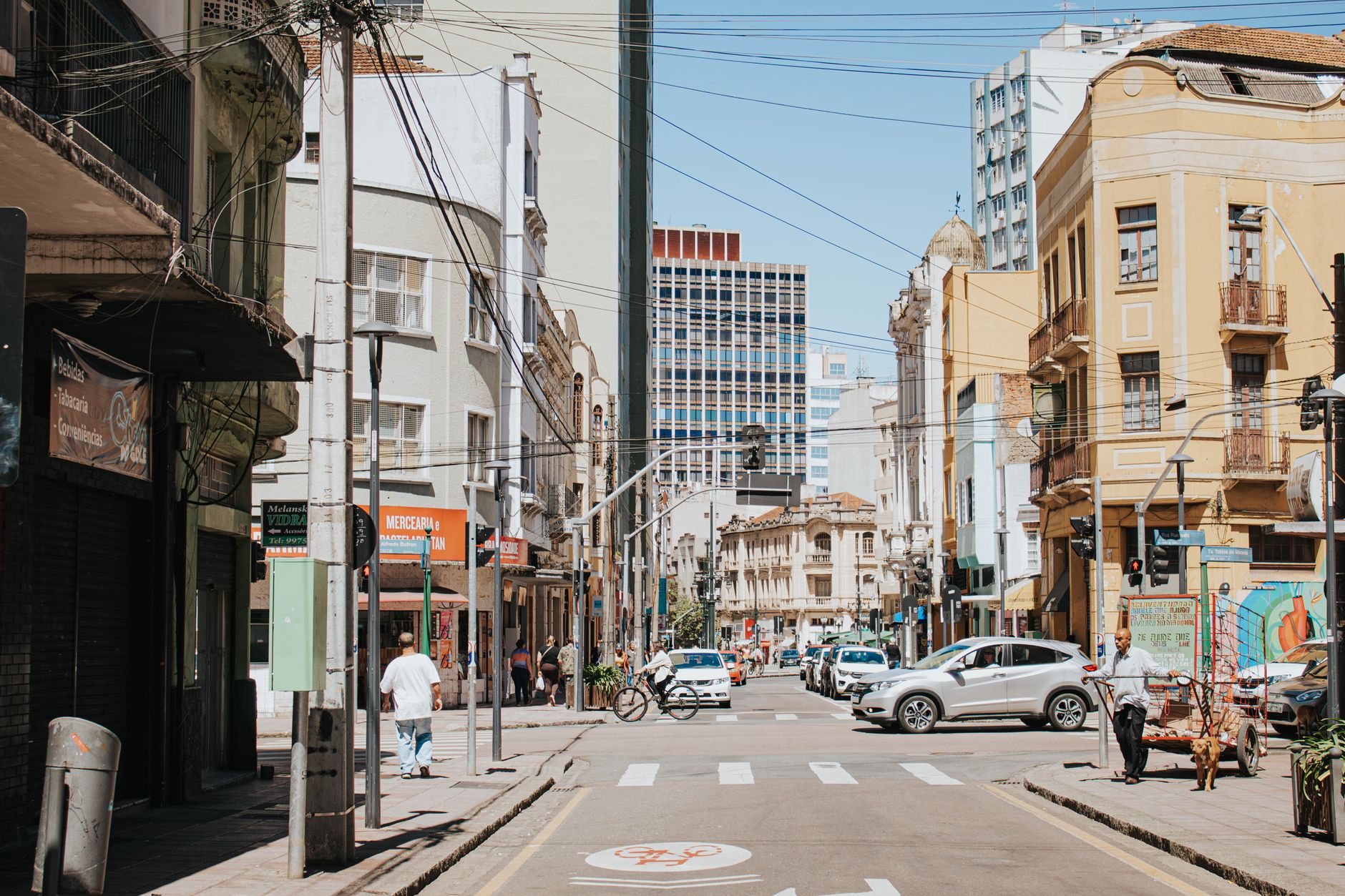 Lively intersection in Curitiba's cityscape with vehicles and pedestrians.