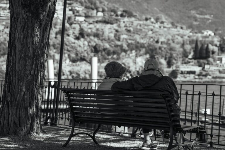 Serene moment of an elderly couple on a bench overlooking Lake Como.
