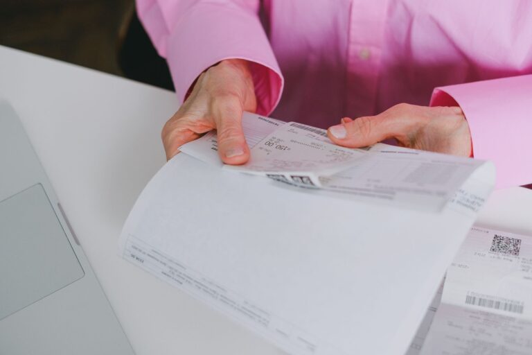 Business person handling paper receipts, meticulously organized.