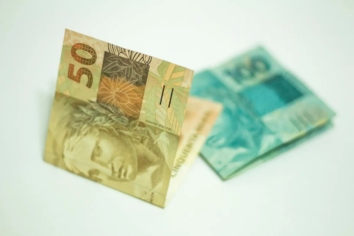 A close-up shot showcasing Brazilian banknotes, featuring 50 and 100 real bills.